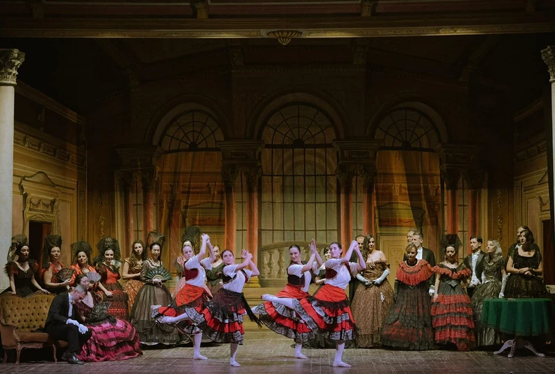 Spettacolo di danza su un palcoscenico storico, ballerine in costume tra gli archi della scenografia