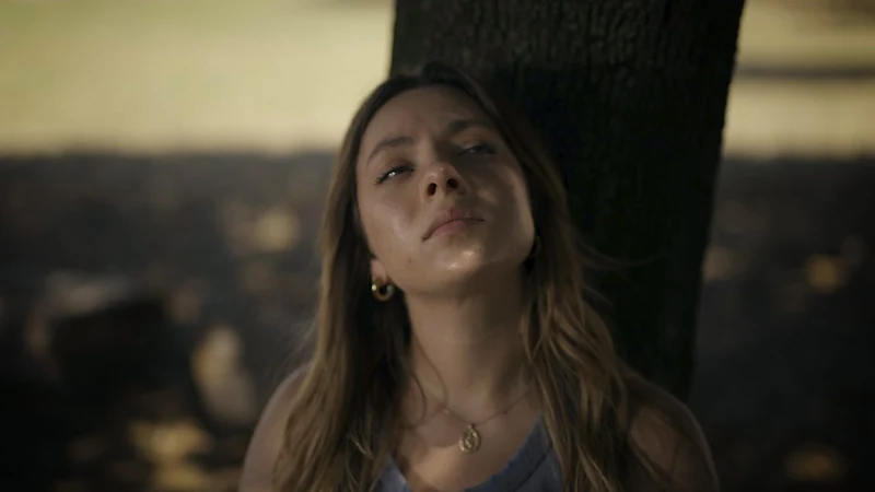 Ragazza che guarda in alto con gli occhi lucidi, luce calda del tramonto