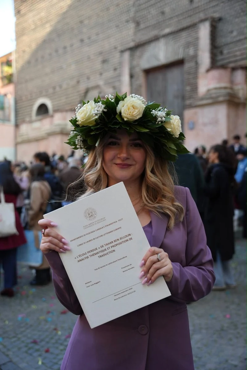 Neolaureata con la corona d'alloro che mostra la pergamena di laurea