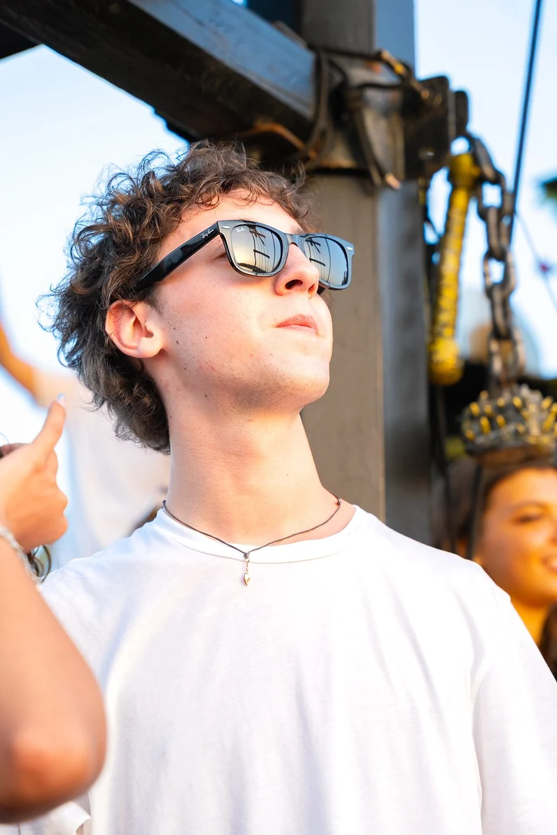 Ragazzo con gli occhiali da sole che guarda in alto durante una festa