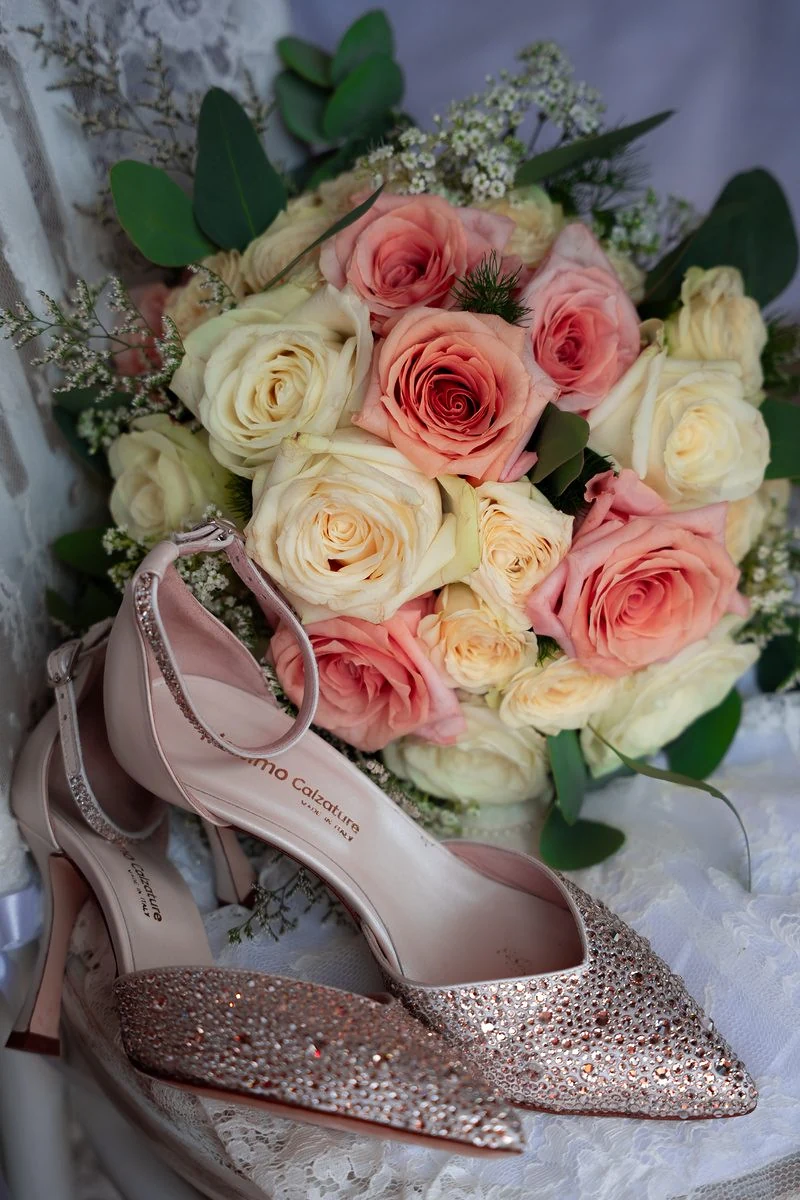 Bouquet di rose rosa e bianche con le scarpe da sposa glitterate