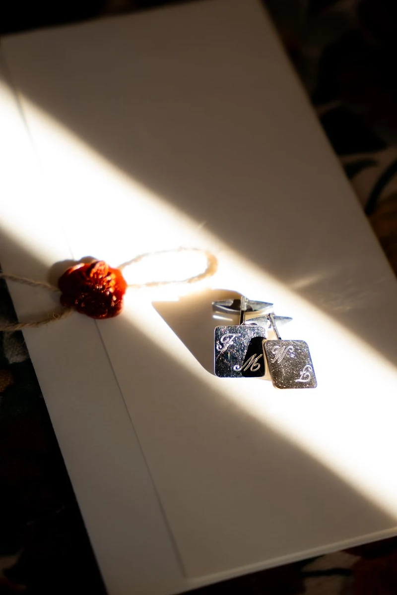 Gemelli dello sposo e sigillo di ceralacca in un fascio di luce