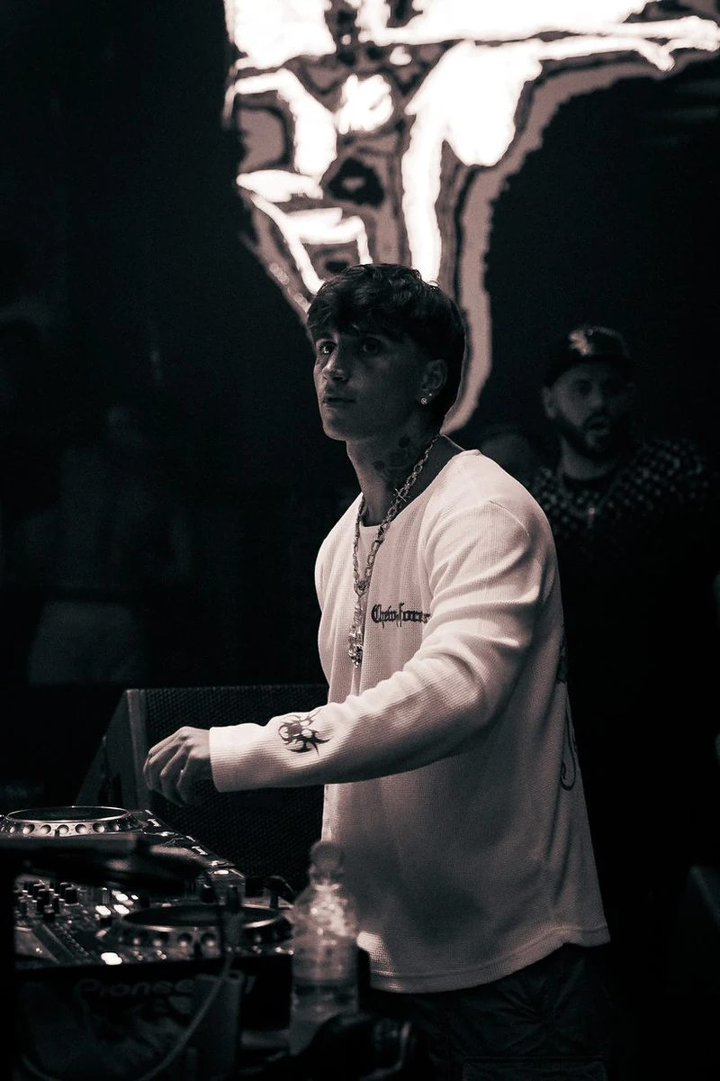 Dj alla console in penombra durante una serata