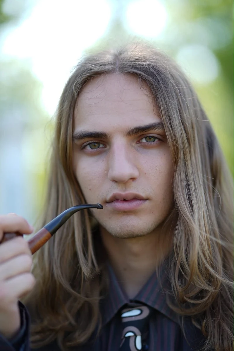 Ritratto di un ragazzo dai capelli lunghi con la pipa