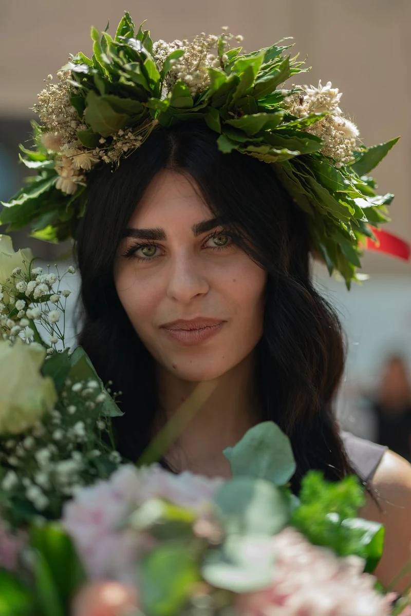 Ritratto di una ragazza con una corona di foglie e fiori